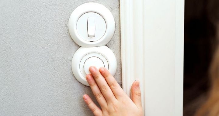 Käsi valonkatkaisijalla kotona